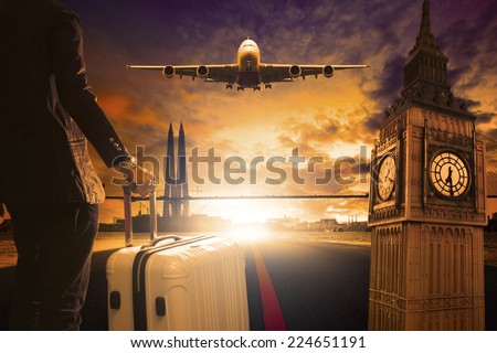 young business man standing with luggage on urban airport runway and jet plane flying above against beautiful urban scene and big ben london behind