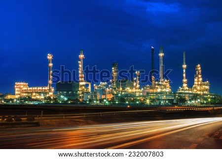oil refinery plant against beautiful blue dusky sky and vehicle lighting on asphalt road use as land transport and oil power industry topic background