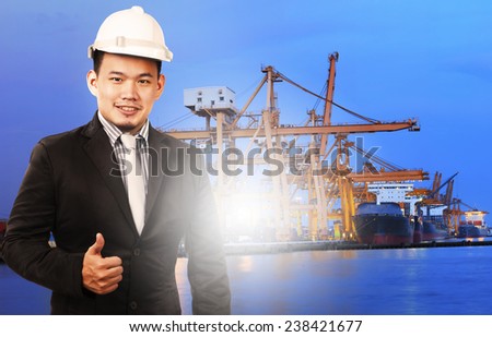 young manager man standing and sign good quality control of port shipping import export and logistic industry service against ship in comercial ship piers