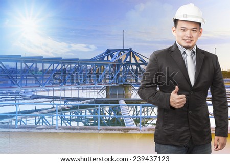 environmental engineering man standing in front of waterworks in heavy industry plant and sign good condition and clean environment for good cooperated organization company