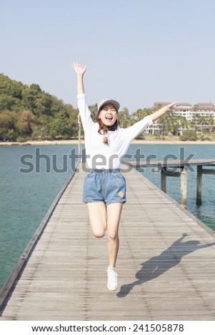 portrait of young beautiful woman jumping with happy emotion on wood piers at sea side use for people activities in holiday vacation