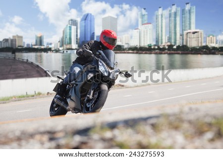 young man riding big bike motorcycle on city road against urban and town building scene background use for people and convenience vehicle to traveling in town