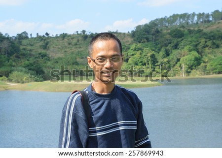 thin asian man wearing eyes glass with skin head hair fashion smiling to camera
