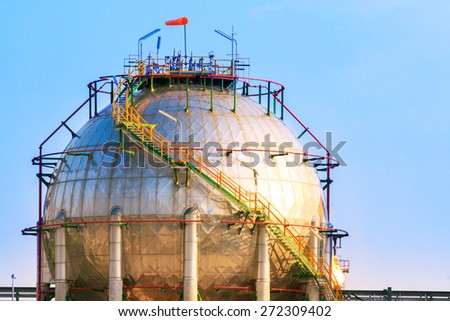 natural petrochemical gas storage tank in heavy petroleum industry estate against clear blue sky background