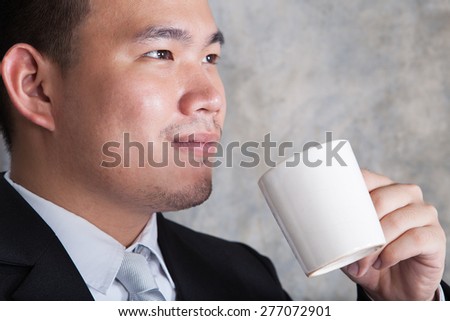 close up face of business man and ceramic coffee cup in hand with happiness emotion in eyes