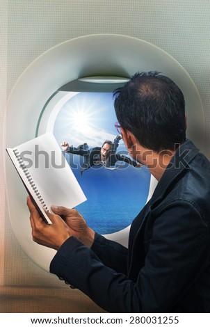 business man reading book in passenger plane seat and looking to out side of plane see another business man flying beside a window