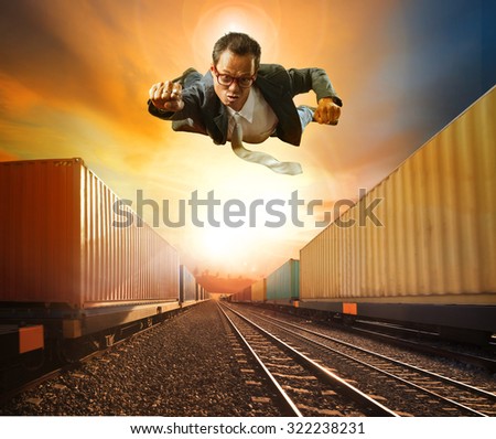 business man flying and industry container trains running on railways track against beautiful sun set sky use for land transport and logistic business