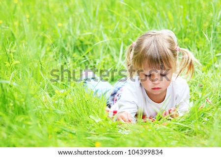 a beautiful little girl drawing pencils on the nature of
