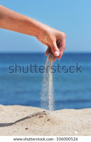 hand pours the sand