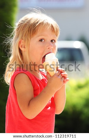 beautiful little girl on nature  eating ice cream