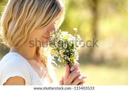 young woman smelling flowers in nature