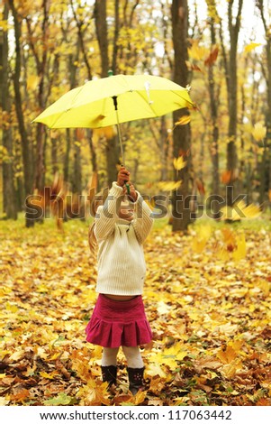 beautiful little girl in the autumn forest with umbrella