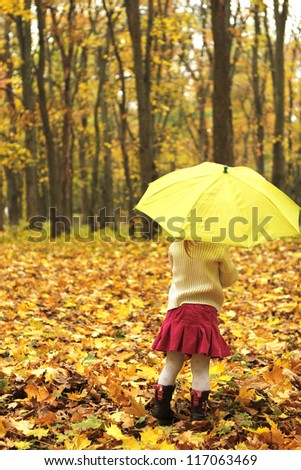 beautiful little girl in the autumn forest with umbrella