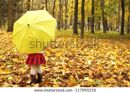 beautiful little girl with umbrella in the autumn forest