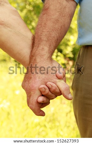 a two hands of an elderly couple in love