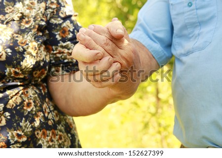 a two hands of an elderly couple in love