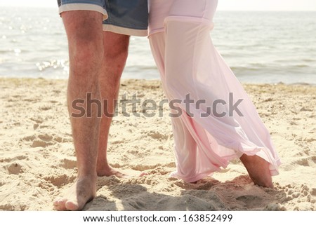 a Pregnant couple in love feet on the beach