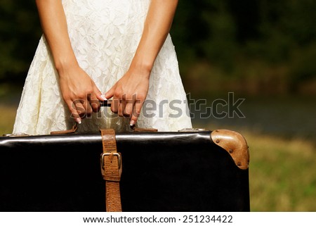 a hand of a young woman with a suitcase