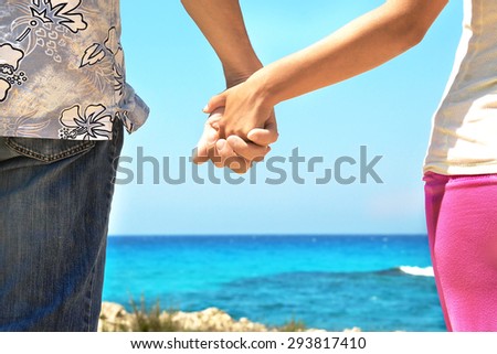 Two hands in love couple on the beach