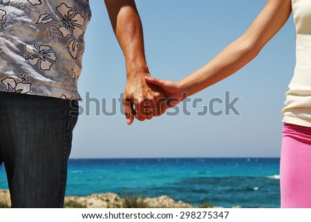 a Two hands in love couple on the shore of the sea