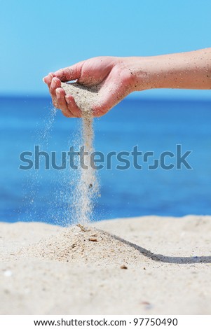 hand pours the sand