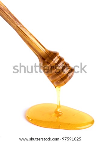 honey flowing down from a wooden honey dipper isolated on white background