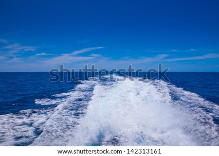 speedy boat prop wash, white wake on the blue ocean sea