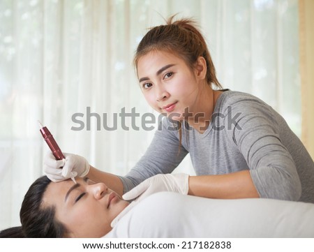 Professional permanent makeup applying on eyebrow