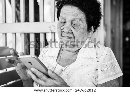 Black and white image of Senior asian woman  with smart phone
