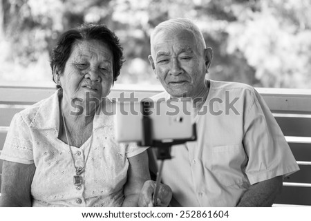 Black and white image of Happy senior couple posing for a selfie at home