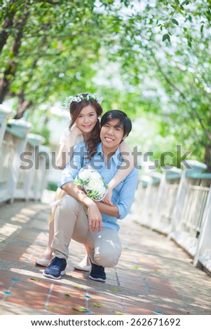 Loving asian couple under tree in the park