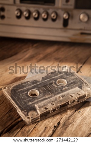 Old cassette tapes and cassette player on wooden surface