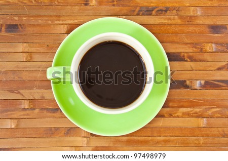 green cup of hot coffee on wood background