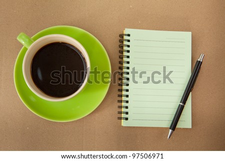 green cup of hot coffee and note paper on wood background
