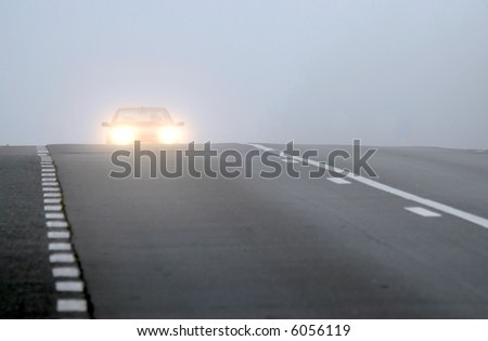 Car appearing through fog with headlights on