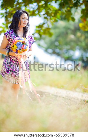 stock photo Pre wedding bride with bouquet standing at meadow field