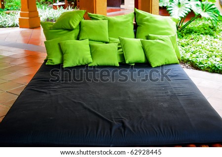 Very big bed with many green pillows