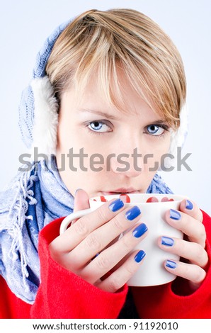 Winter portrait of a blue-eyed girl holding cup of tea. Image has clipping path.
