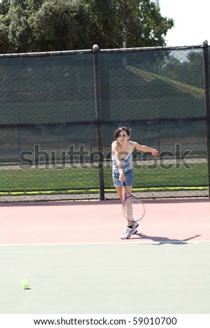 young latina girl swinging tennis racket outdoors court