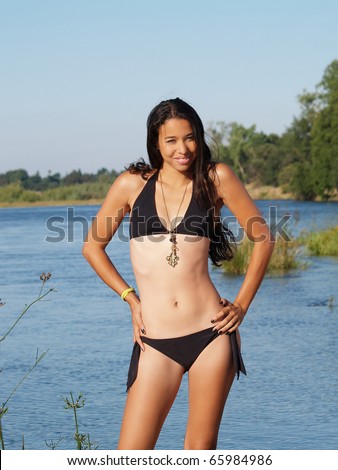 Young skinny woman bikini at river standing