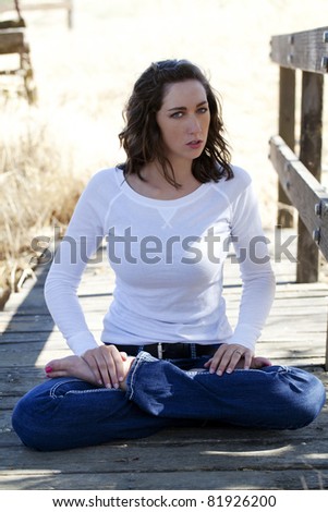 young caucasian woman sitting jeans white top angry expression