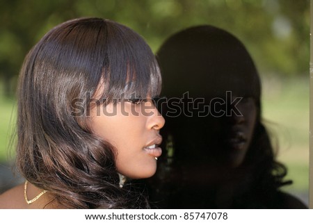 Young attractive black woman profile reflected in window