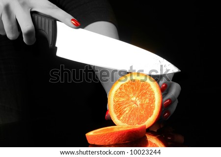 woman is chopping orange on the black background 2