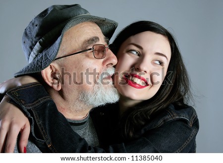 a grandpa is kissing his granddaughter and she is smiling