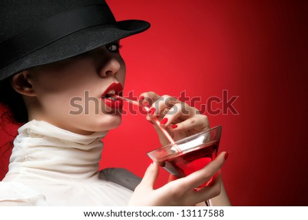 a glamor lady with hat is drinking cocktail
