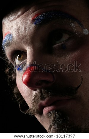 a portrait of a sad clown on black