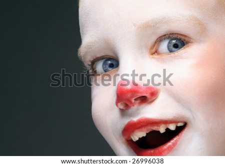 portrait of make up clown boy with red nose