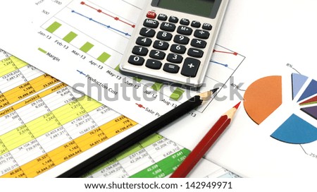 Business concept with pencils, calculator and financial table and graph