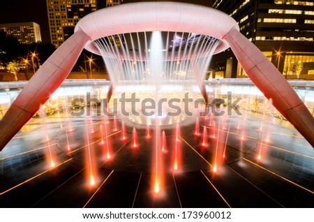 SINGAPORE-JAN 24: Fountain of Wealth with Suntec Towers at dusk on JAN 24,2014 in Singapore. Fountain of wealth is the biggest fountain in Singapore located Suntec Towers, SINGAPORE.
