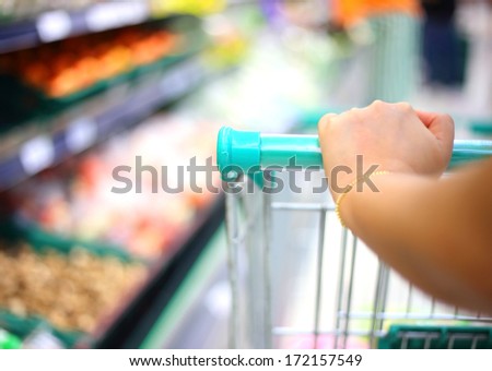 woman hand with shopping cart in supermarket